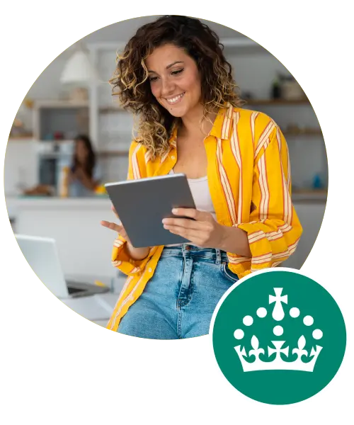 Smiling woman in a yellow striped shirt using a tablet, with a background of a modern kitchen, featuring HMRC logo symbolising compliance with Making Tax Digital.